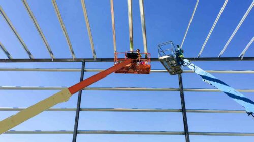 Two guys Install Purlins