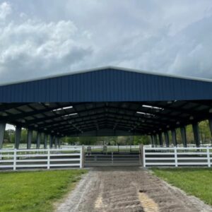 Blue-roofed 50x60 equestrian arena with white fencing