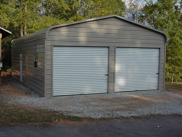 24×21×8 metal building installed by Steel and Stud — standard rounded-edge roof and a 9×7 roll-up door
