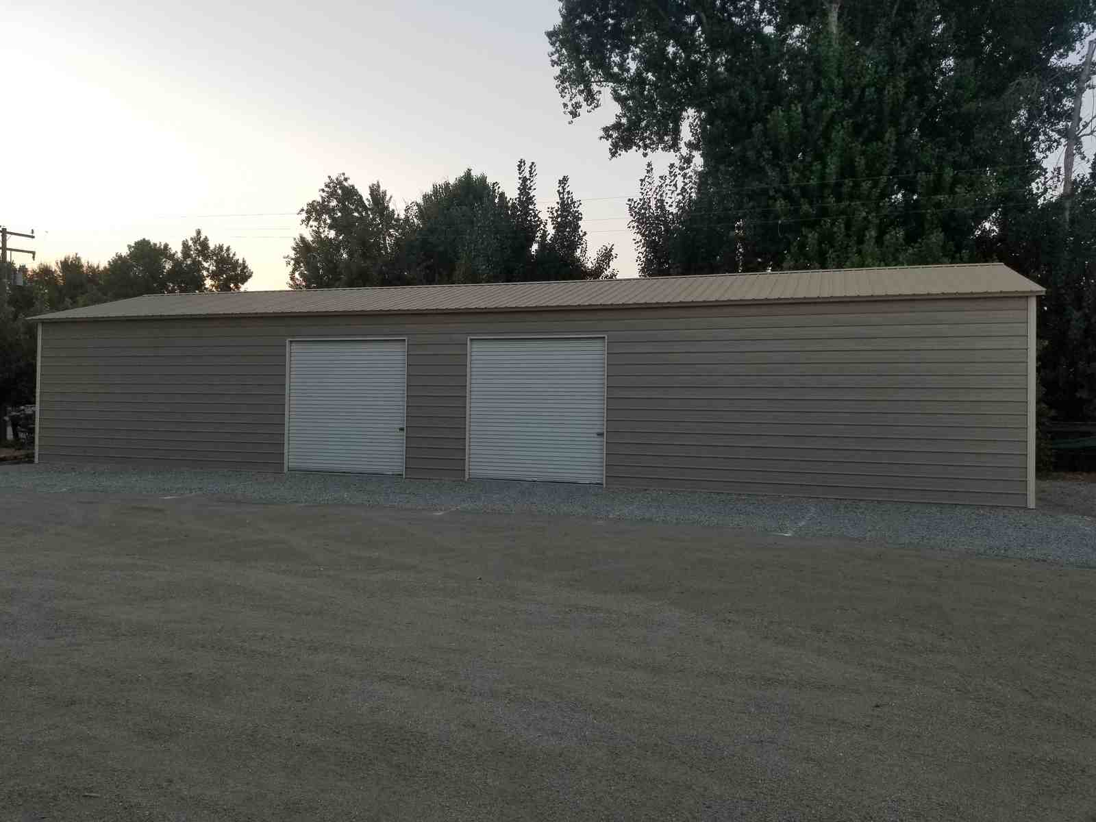 25×76×12 metal building installed by Steel and Stud — A-frame roof with vertical panels and a 10×10 roll-up door