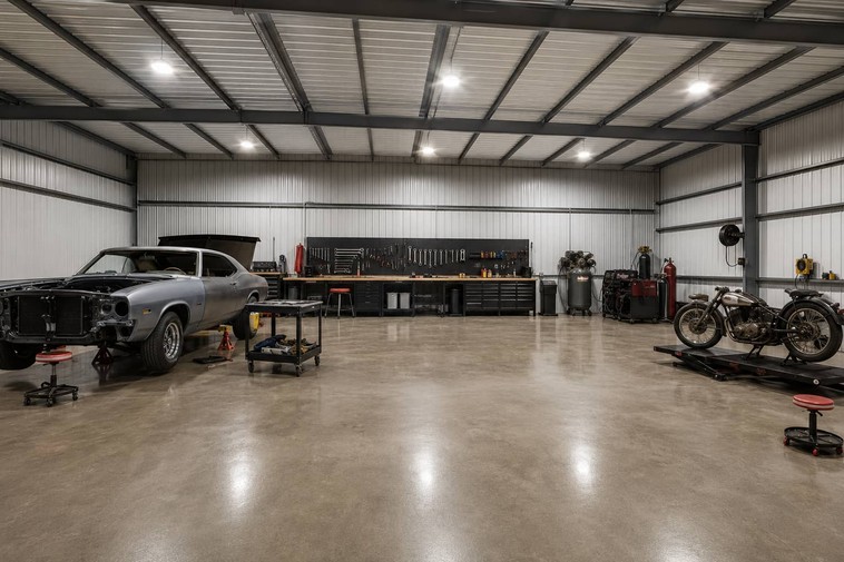 Metal building interior hobby garage with muscle car project, workbench, and motorcycles