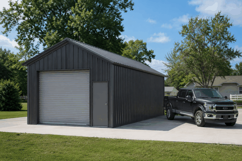 Charcoal steel garage with gray roll-up door and black pickup truck parked beside it
