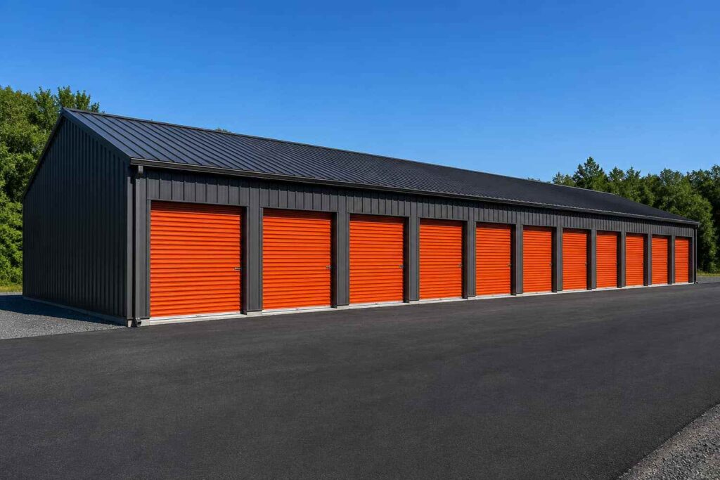 Black steel structure self storage building with row of orange roll-up unit doors